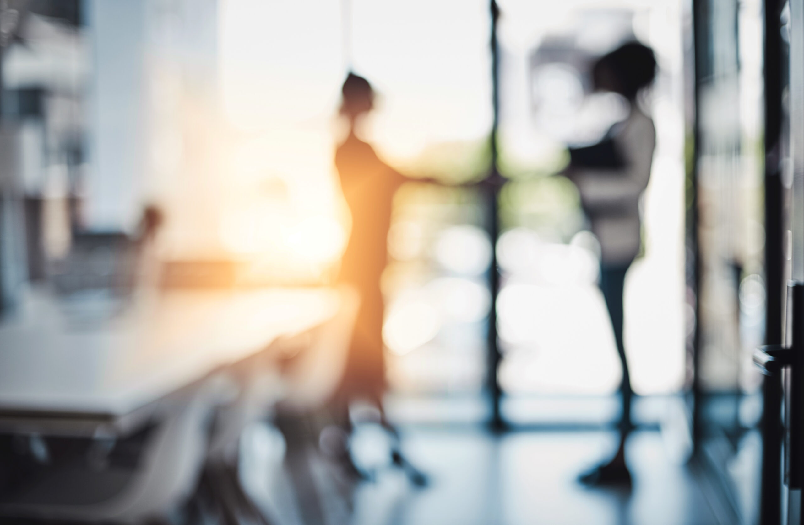 Its been a busy day of doing deals. Defocused shot of two businesswomen shaking hands in an office